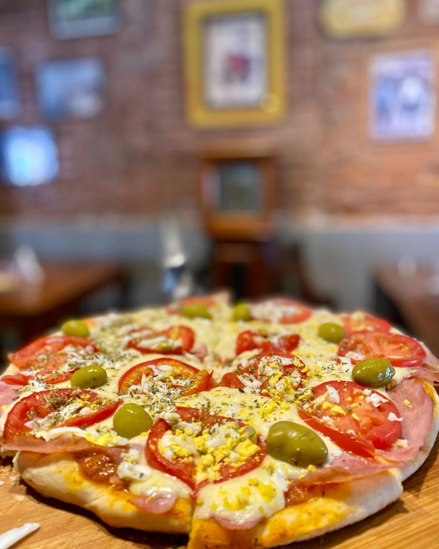 Pizza con jamón, tomate, huevo y aceitunas